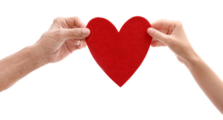 Old male and young female hands with heart figure on white background