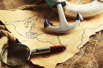 Lifebuoy with magnifier and anchor on old map. Happy Columbus day concept