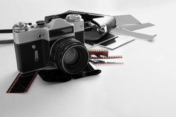 Vintage photo camera with photos on white table