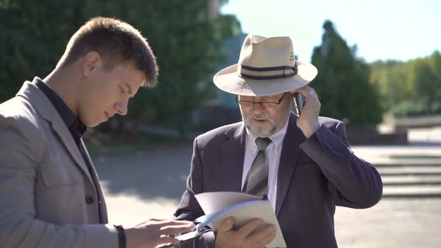 Two businessmen using a digital tablet and calling. 4K