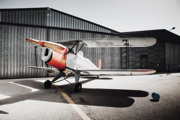 Vintage old plane in front of the hangar. - 119429947