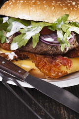 juicy  bacon cheese bbq burger on wooden table with fries