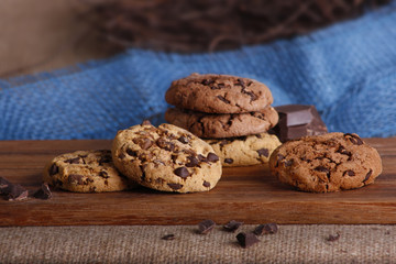 Frisch gebackene Kekse und Schokolade auf einem Holzbrettchen