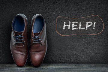 Help text on black board and business shoes