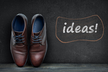 Idea text on black board and business shoes