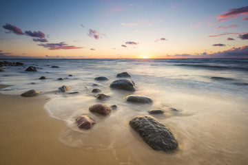 Zachód słońca nad bałtycką plażą,głazy piastowskie na wyspie Wolin
