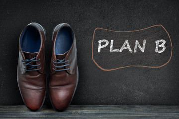 Plan B text on black board and business shoes