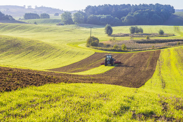 Traktor rolniczy podczas prac polowych na polu - obrazy, fototapety, plakaty