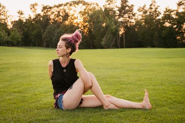 woman with dreadlocks doing yoga exercises outdoors