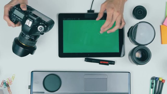 Tablet from above. Unrecognizable creative designer working with tablet on his workplace. Top view. 4K.