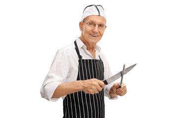 Elderly butcher sharpening his knife
