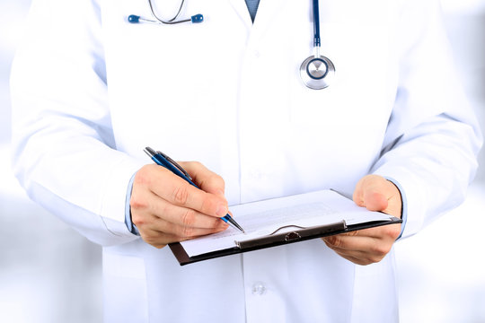 young medical doctor  with a stethoscope around his neck  holdin