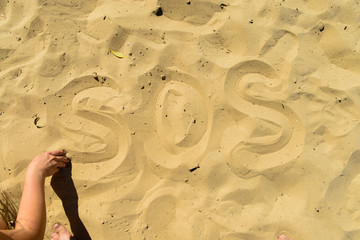 Obraz premium inscription SOS in the sand on the beach