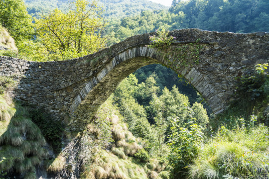 Ancient stone bridge called “Ponte della Gula” in Val Mastallone, Piedmont, Italy