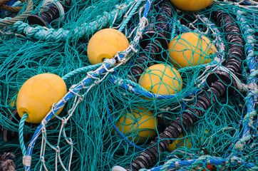 BUOYS AND FISHING NETS. Buoys and tangled fishing nets lie on the waterfront