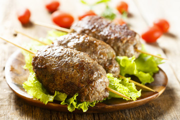 Kebab skewers with green salad and tomatoes