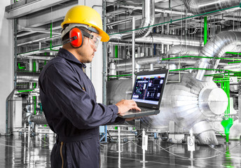 Engineer using laptop computer in thermal power plant factory