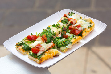 Focaccia bread topped with arugula, tomato and mozzarella,