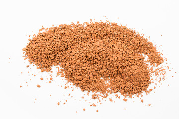 Top view of spread of instant coffee grains on white background.