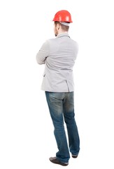 Backview of an engineer in construction helmet stands. guy in a gray jacket waving his arms.