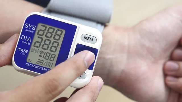 Man checks blood pressure. Wrist meter close up.