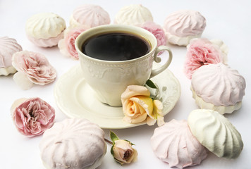 One cup of coffee, pink and white zefirs, pink roses on a white background