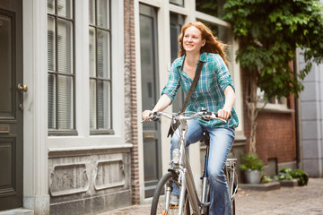 Fototapeta na wymiar Woman Cycling in a City