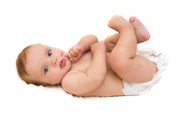 Funny little baby lying down on a blanket . Newborn child relaxing in bed. Nursery for young children. Textile and bedding for kids.

