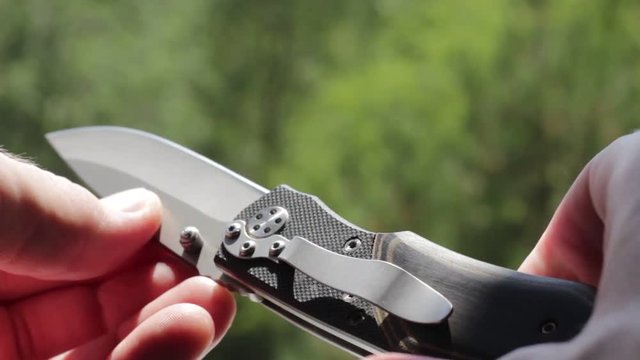 Steel penknife in man's hands