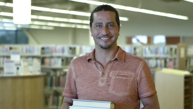 Portrait of man holding library books