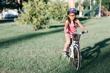 Fototapeta na wymiar happy girl riding bicycle in summer sunset in the park