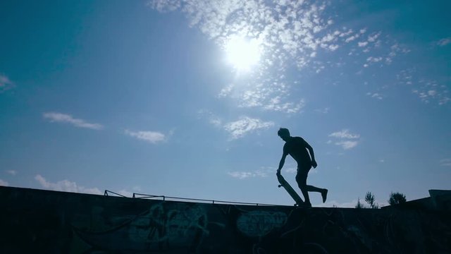 Epic Silhouette of skater riding on skateboard. Sunset sky on a background. Slow motion, steadicam shoot. HD.