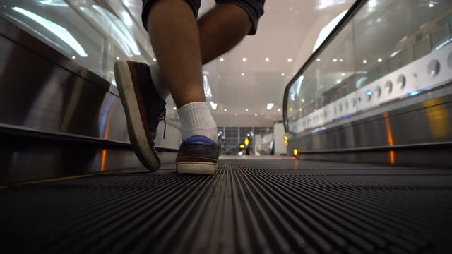 Back view of male legs on escalator at airport