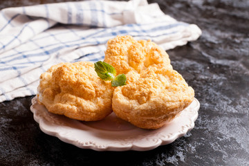 Eclairs with vanilla cream on a white plate