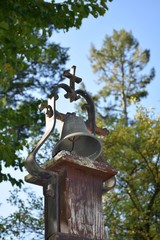 Fototapeta na wymiar Glocke mit Kreuz auf dem Friedhof