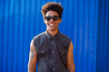 Funky young man portrait over blue background.