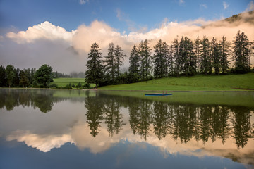 Fototapeta premium Foggy Morning on lake, with beautiful clouds and reflection
