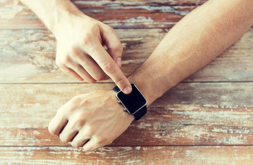 close up of male hands setting smart watch