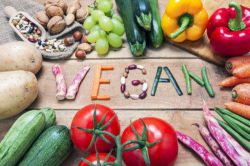 vegan word on wood background and vegetable - food