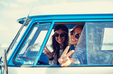 smiling young hippie women driving minivan car