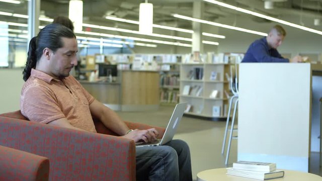 Portrait of man using laptop in the library