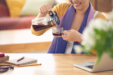 Woman filling her cup with fresh coffee