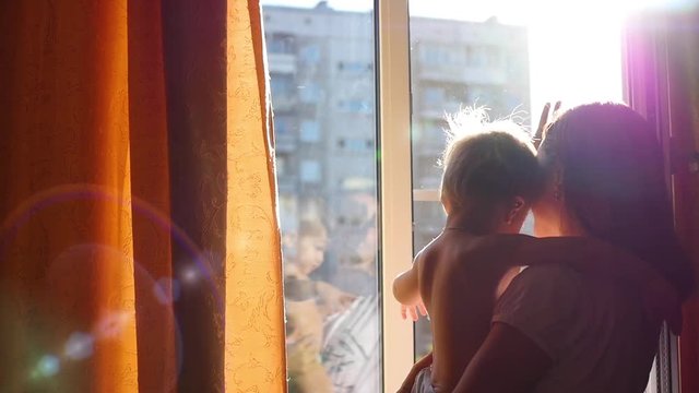 the girl with the kid gently cuddling in the sun