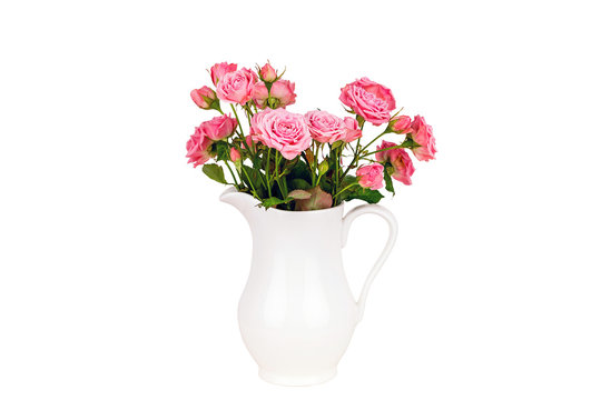 Pink flowers in white jug. Roses in jug. Isolation. Postcard background. Wedding card background. Wedding invitation. Pink roses. Pink roses in a white vase on white background.