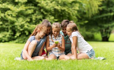 Fototapeta premium kids or friends with smartphone in summer park