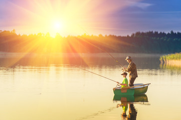 father and son catch fish from a boat at sunset - 119457385