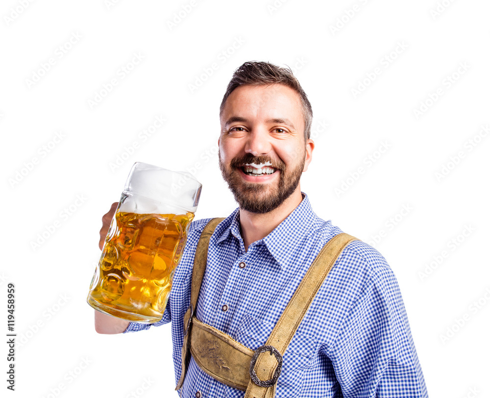 Wall mural Man in traditional bavarian clothes drinking beer