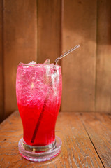 Red soda water on wood background