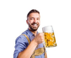 Man in traditional bavarian clothes drinking beer