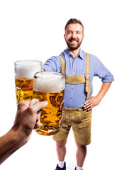 Man in traditional bavarian clothes holding mug of beer